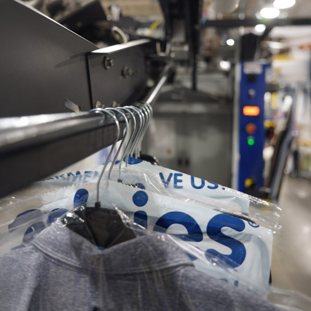 Freshly cleaned garments being sealed in protective bags on Sudsies autobag system