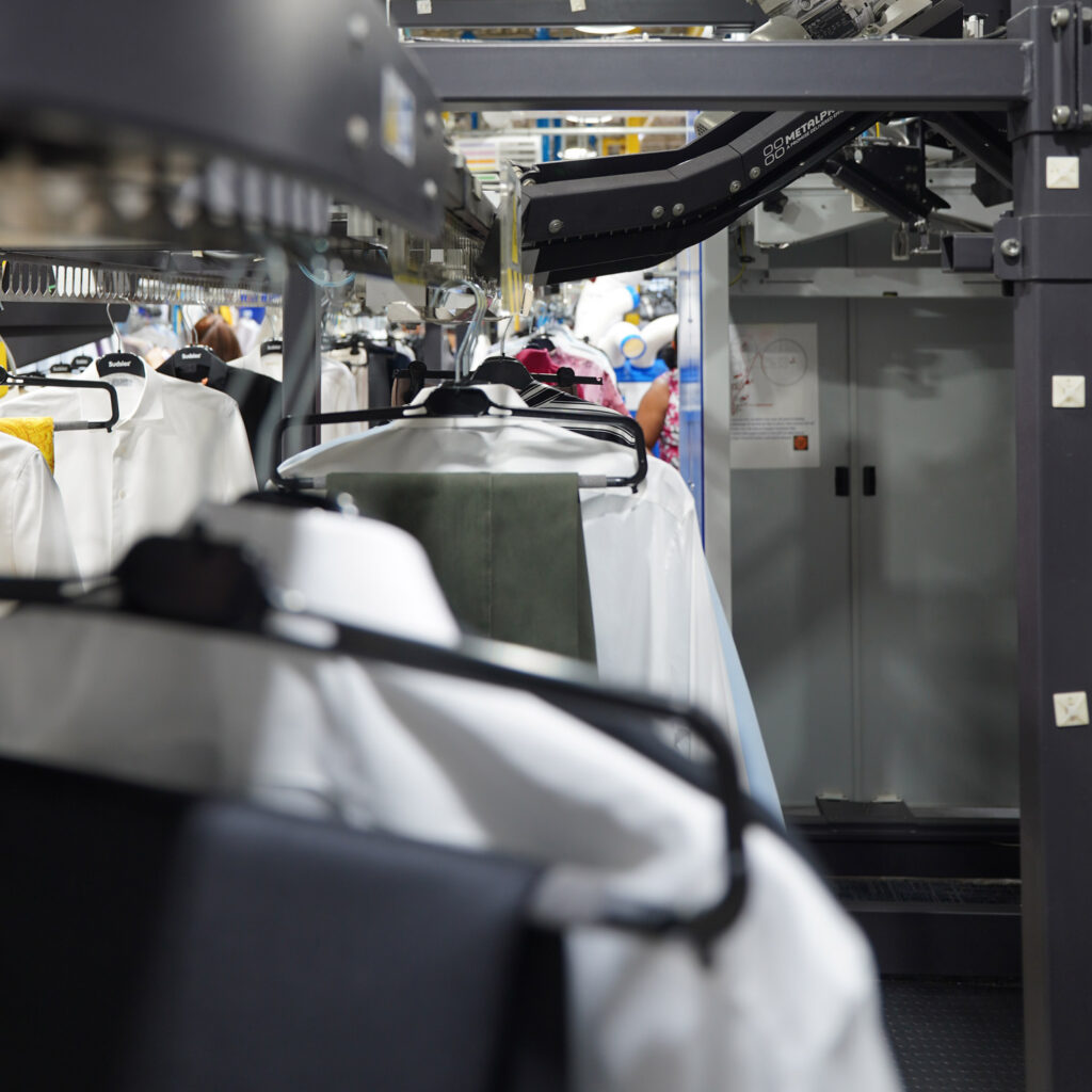 Sudsies automated conveyor system organizing freshly cleaned garments